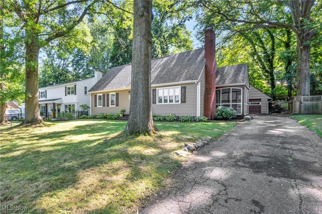 View of home on driveway side featuring attached screened-in porch.