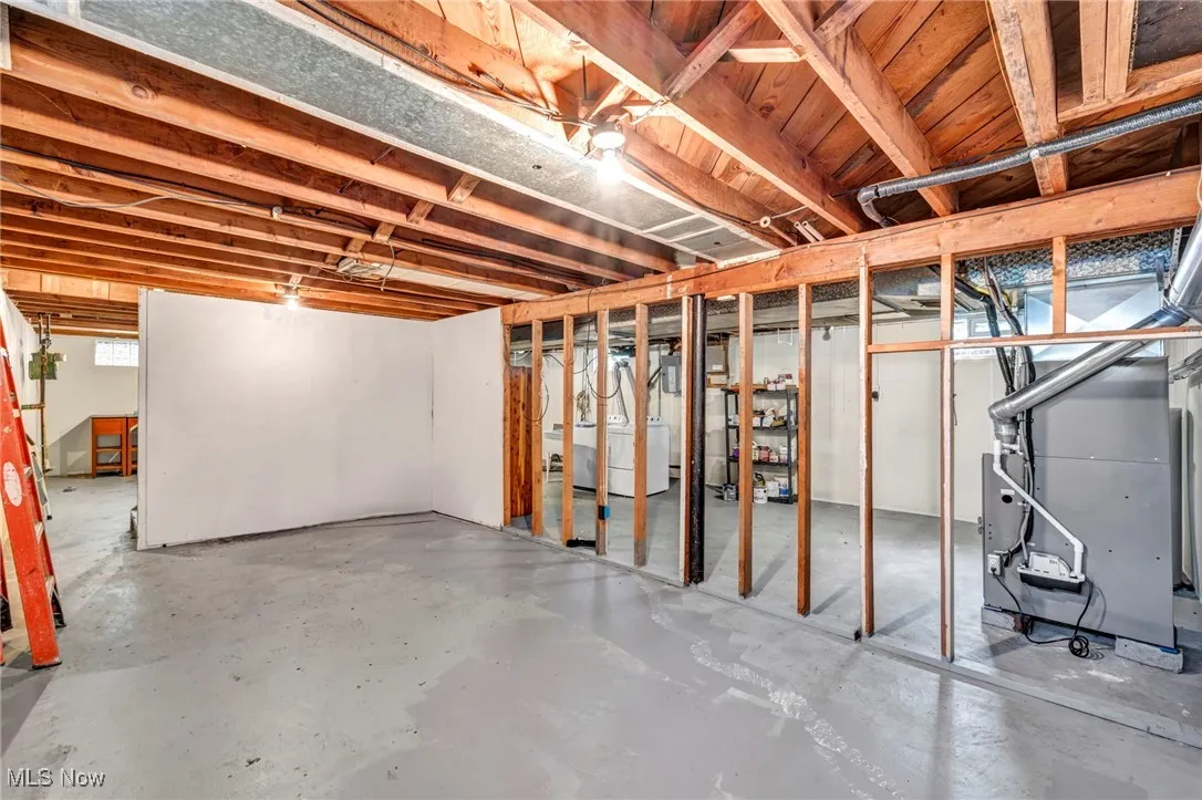 Unfinished basement to the left of the stairs with potential to finish with framing started and wood burning fireplace in space.