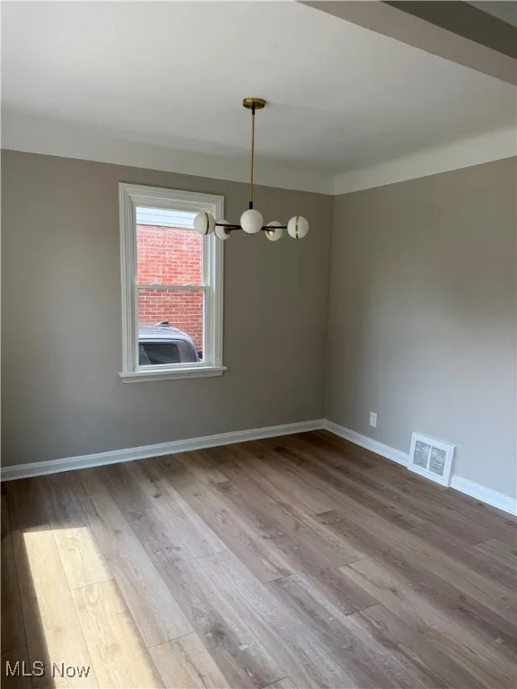 Unfurnished room featuring wood finished floors and baseboards
