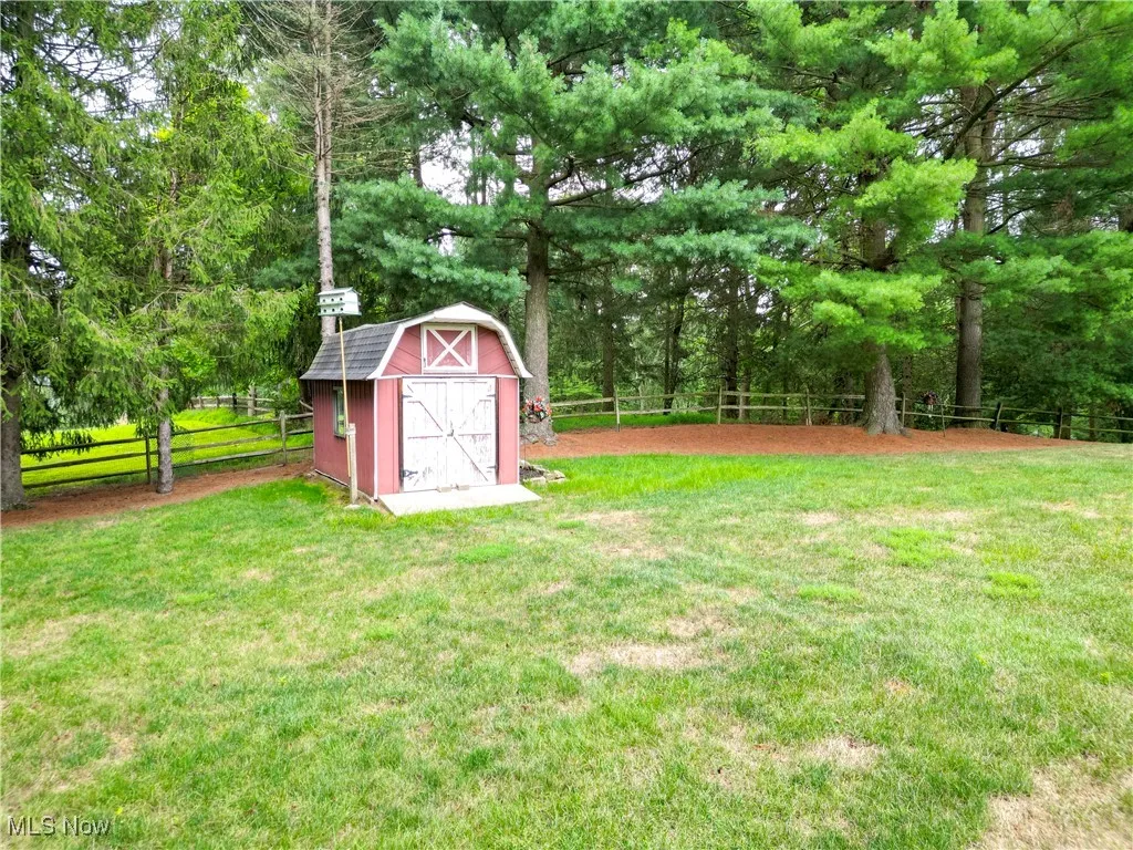 Fenced backyard featuring a storage shed