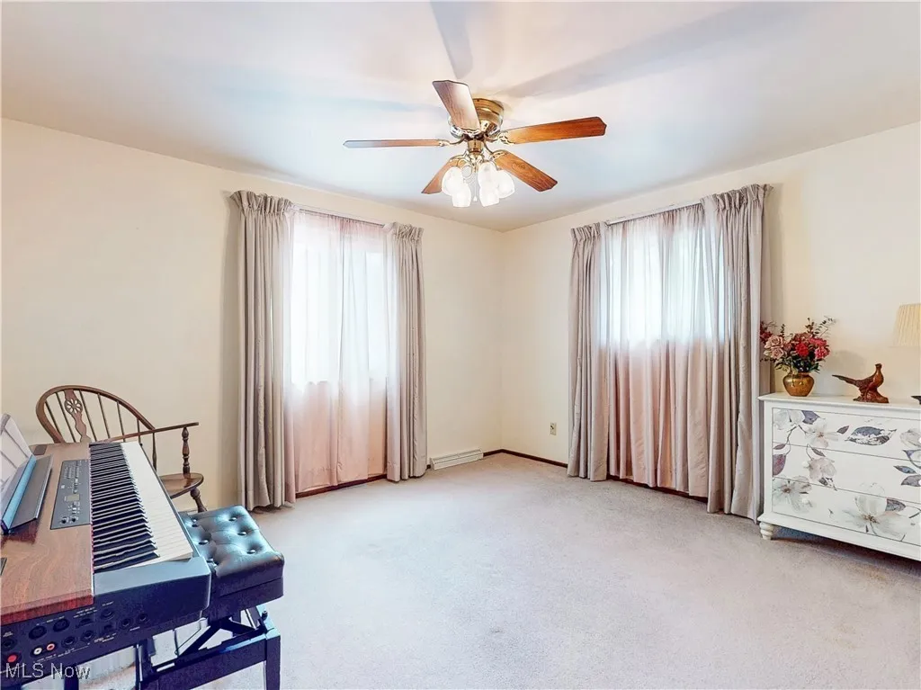 Sitting room featuring plenty of natural light, light colored carpet, and ceiling fan
