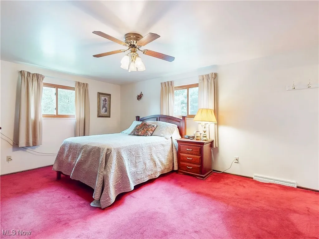 Carpeted bedroom with ceiling fan
