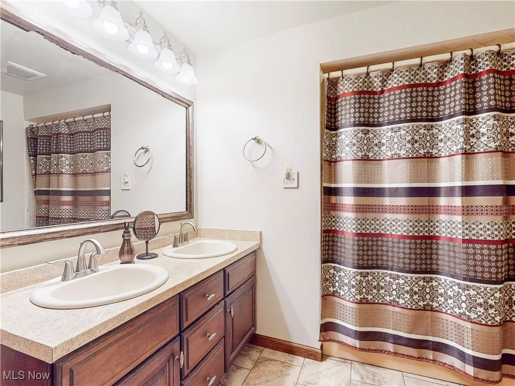 Bathroom with double vanity and tile patterned floors