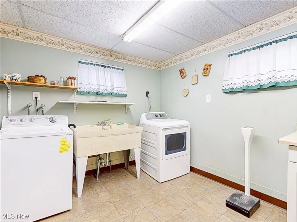 Laundry room featuring washing machine and dryer and light floors
