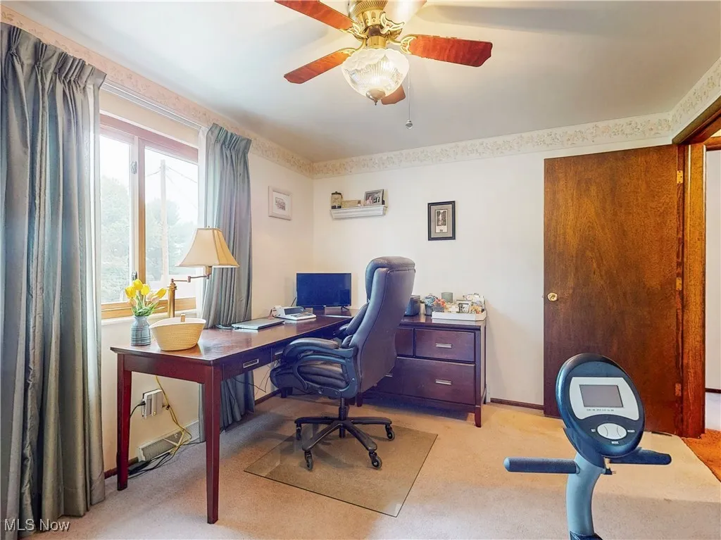 Office space with light colored carpet and ceiling fan