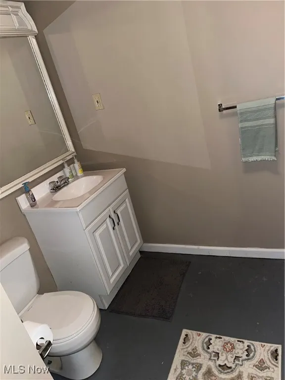 Half bathroom featuring vanity and concrete floors