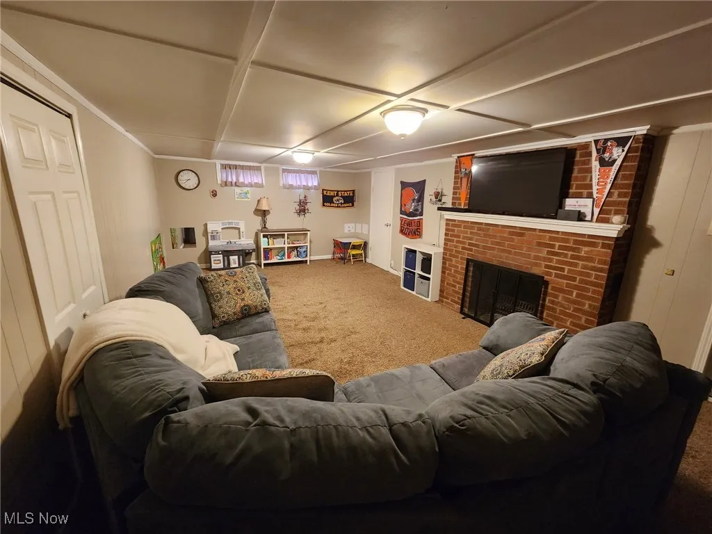 Basement family toom with carpet and woodburning fireplace.