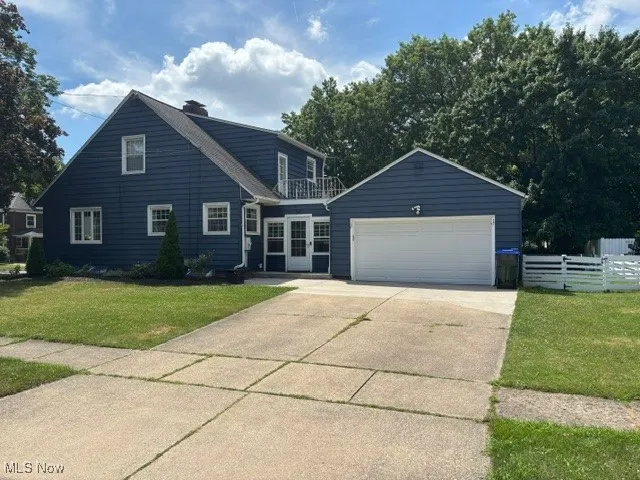 View of side of home with driveway, an attached garage.