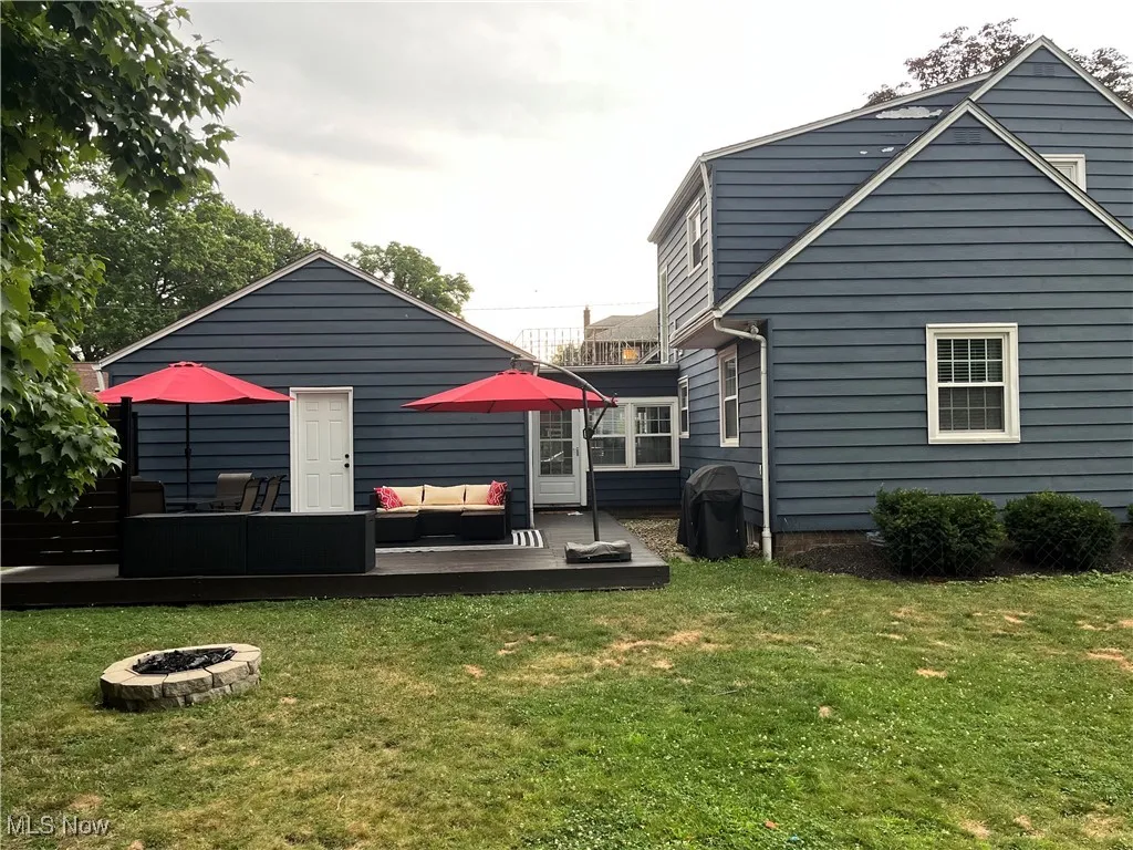 Rear view of house featuring a fire pit, and a wooden deck