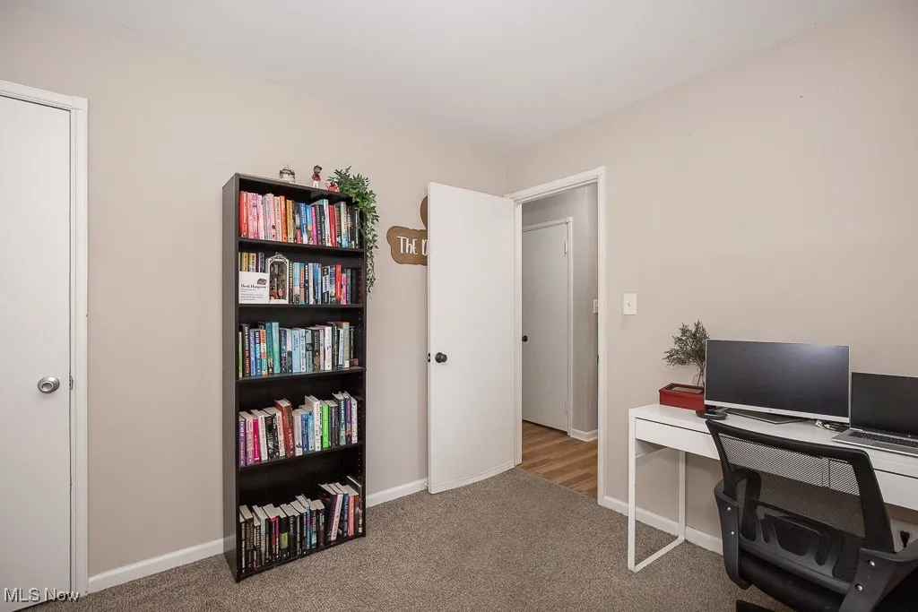 Carpeted office space with baseboards