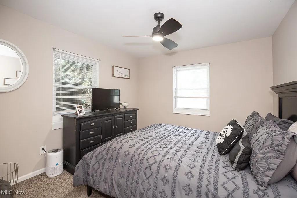 Carpeted bedroom featuring baseboards and a ceiling fan