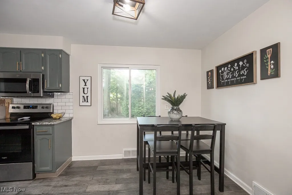 Dining area featuring dark wood-style flooring and baseboards