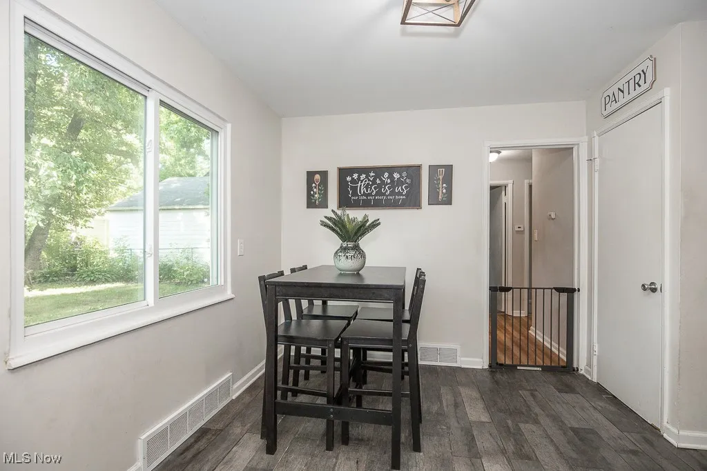 Dining space featuring dark wood-type flooring and baseboards
