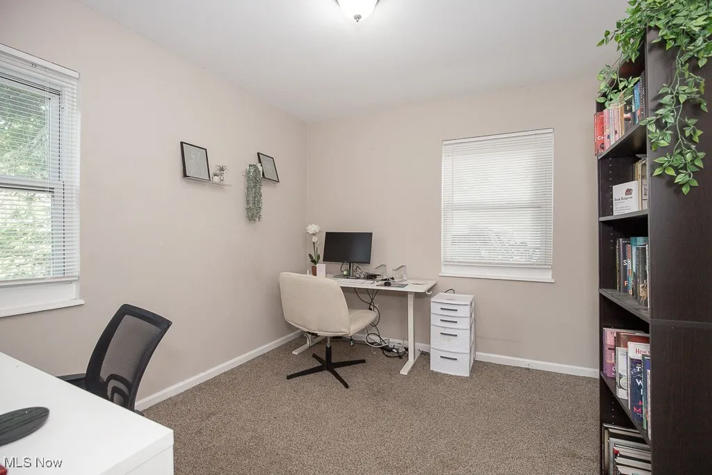 Carpeted office space with baseboards