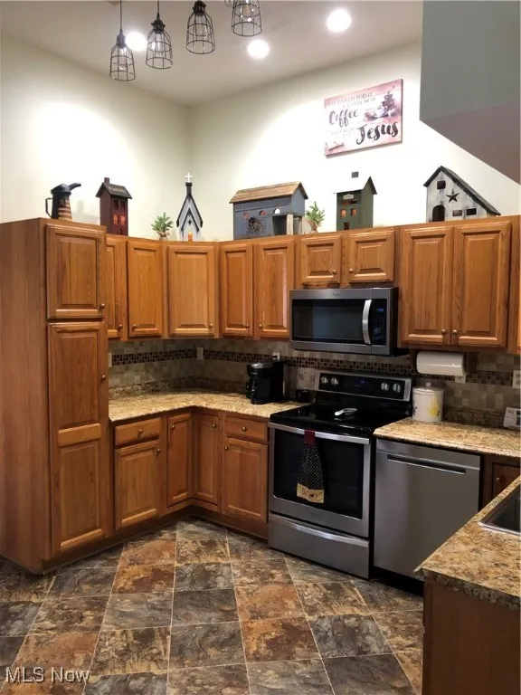 Kitchen featuring range, dishwasher, tasteful backsplash, brown cabinetry, and recessed lighting