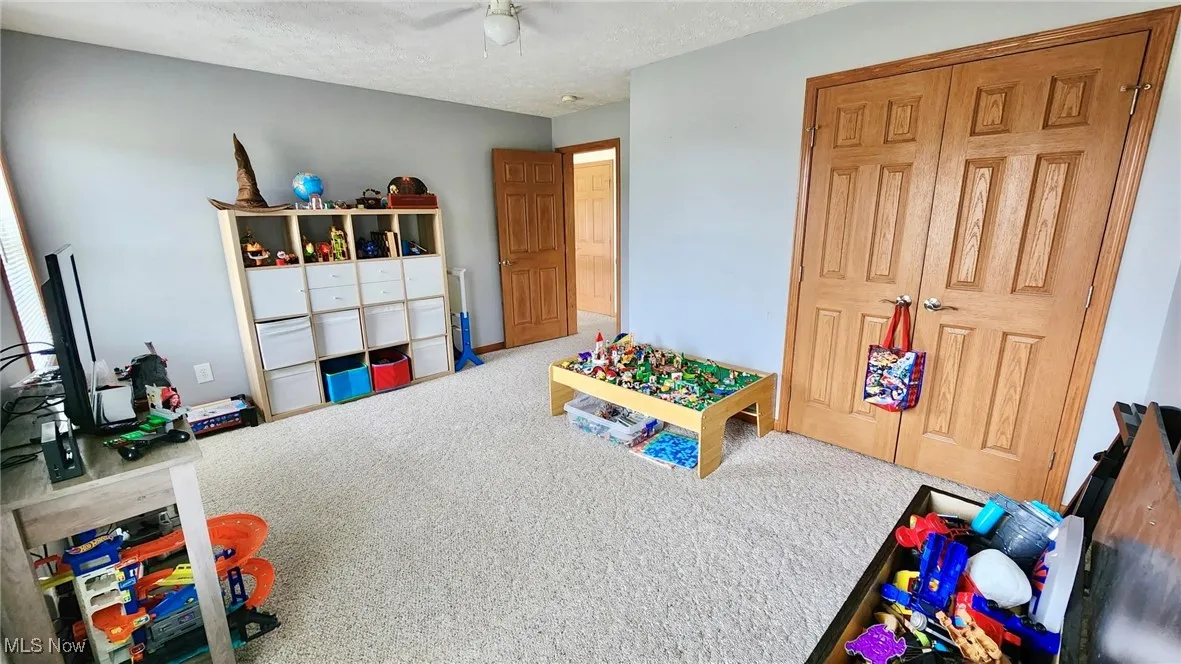 Playroom with carpet and a textured ceiling