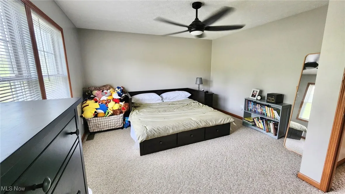 Bedroom featuring carpet floors, ceiling fan, and a textured ceiling