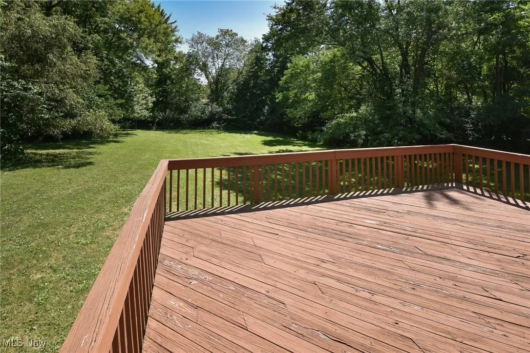 Wooden terrace featuring a yard