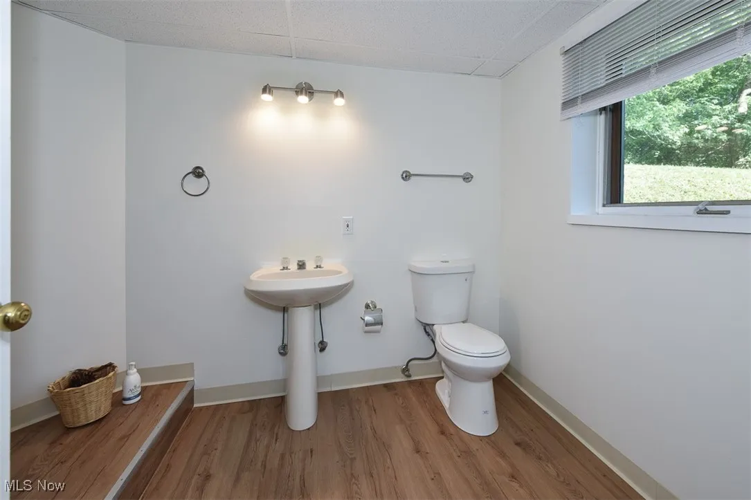 Half bath with wood finished floors and a drop ceiling