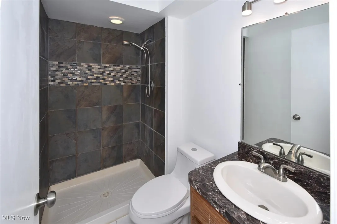 Full bathroom featuring a tile shower and vanity