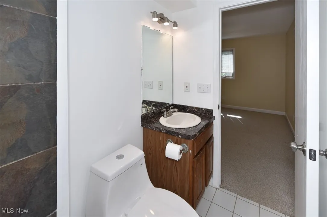 Half bath featuring vanity and tile patterned floors