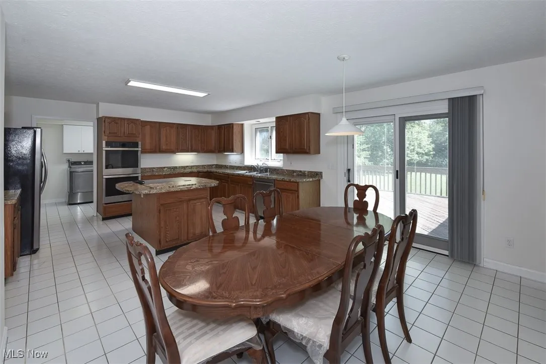 Dining area with light tile patterned floors and washer / dryer