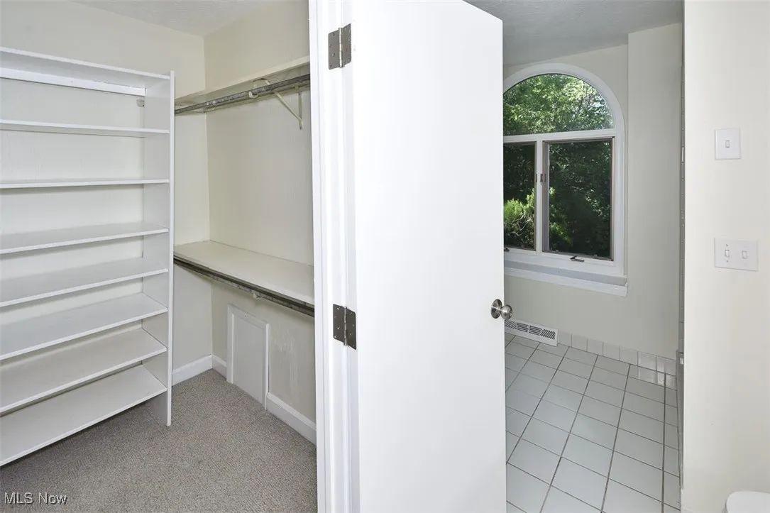 Spacious closet with light tile patterned floors