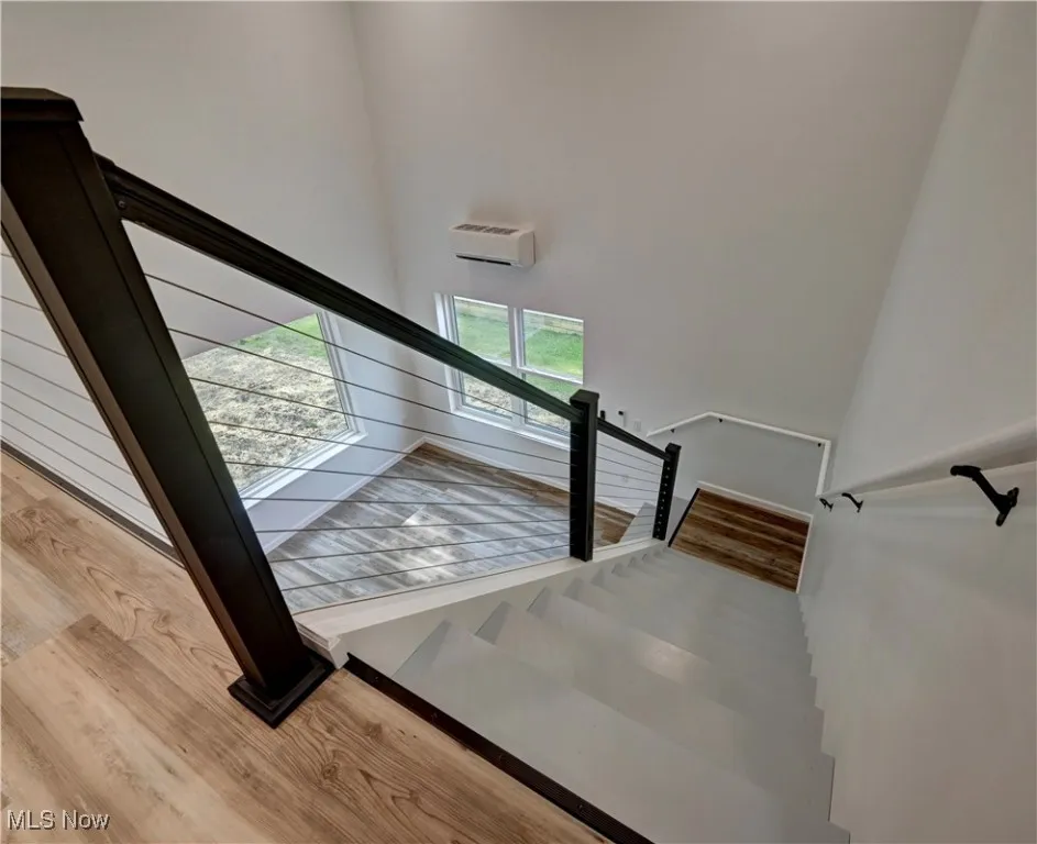 Stairway featuring wood finished floors and a high ceiling