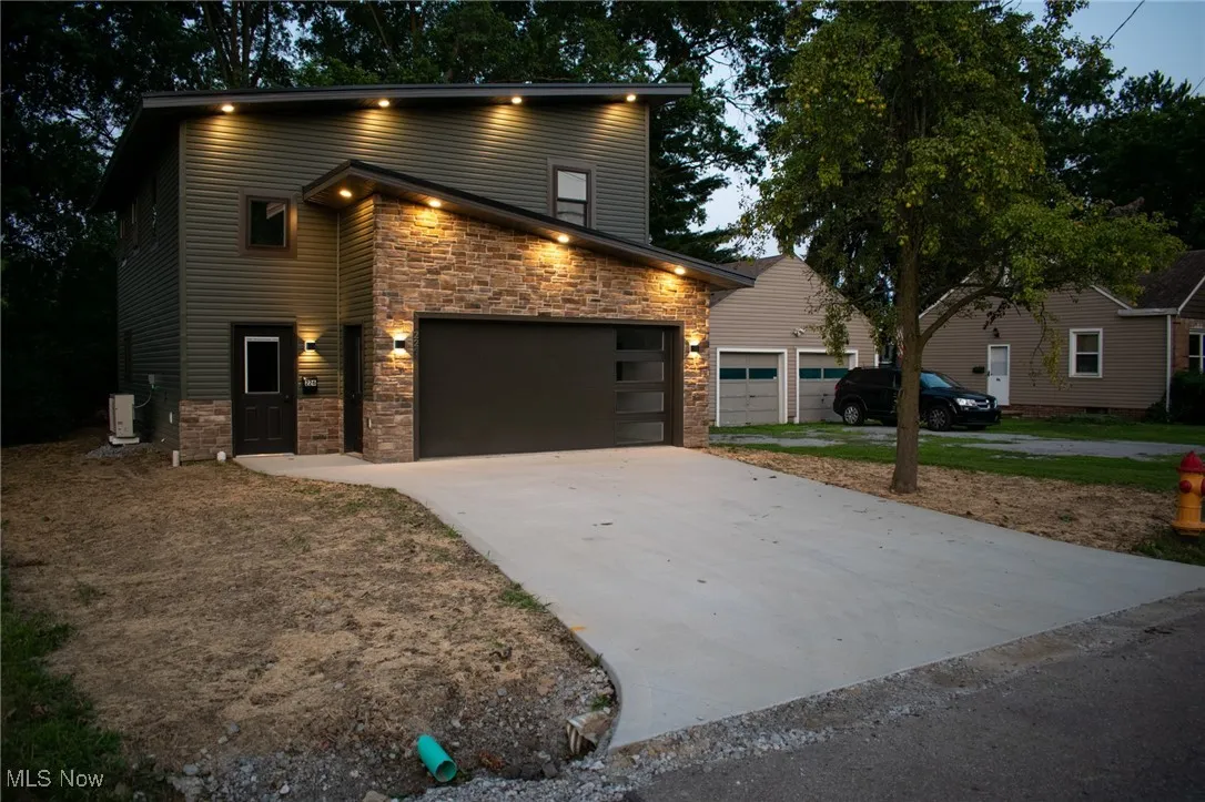Contemporary house featuring stone siding and driveway
