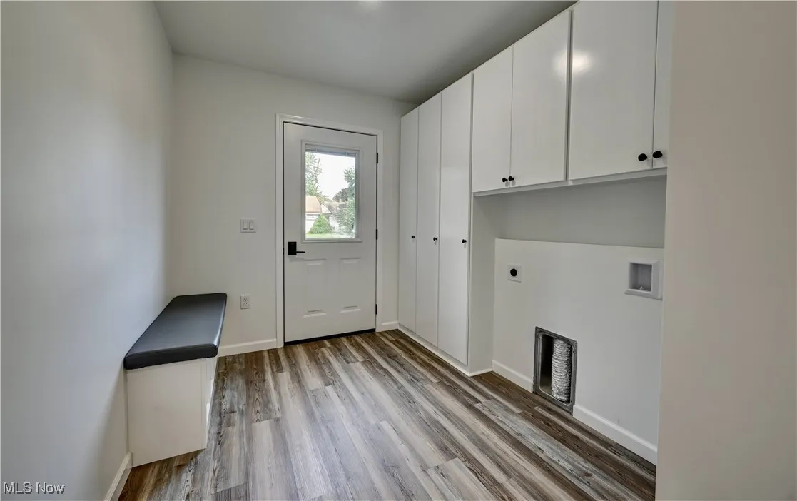 Laundry area with cabinet space, hookup for an electric dryer, washer hookup, and wood finished floors