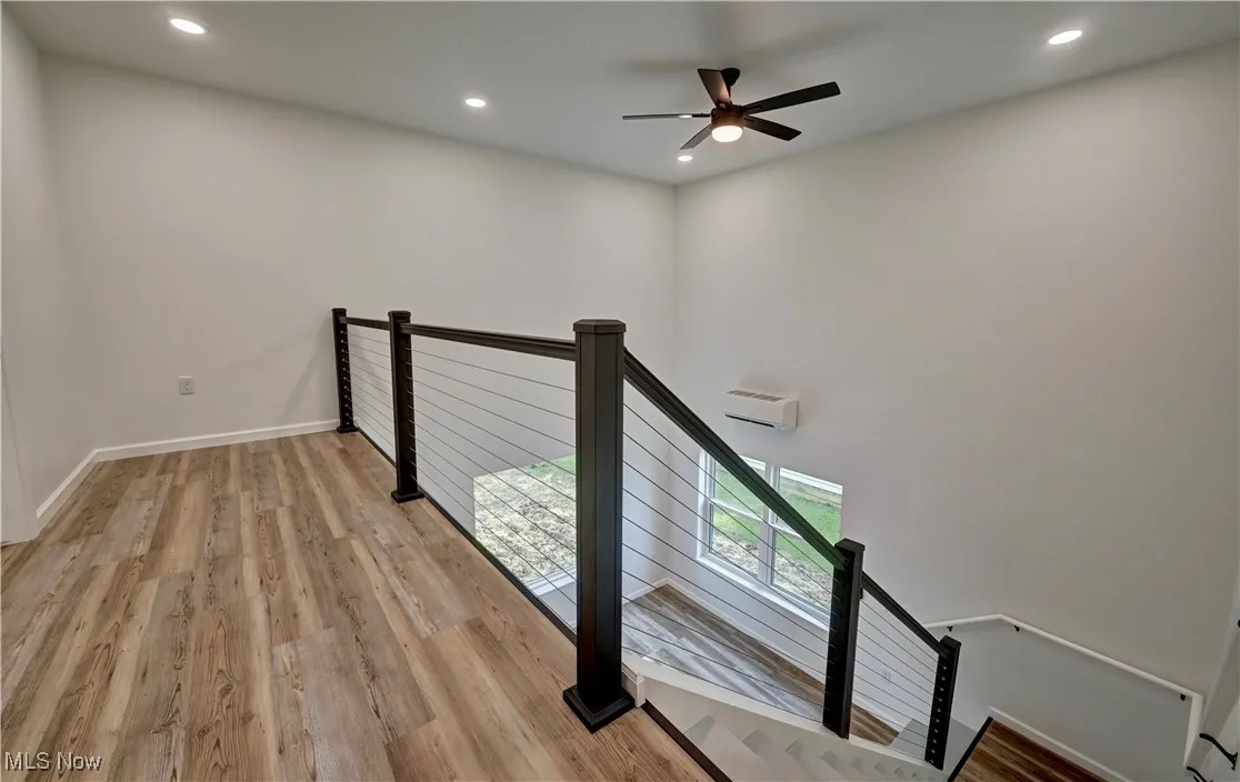 Staircase with wood finished floors, recessed lighting, and ceiling fan