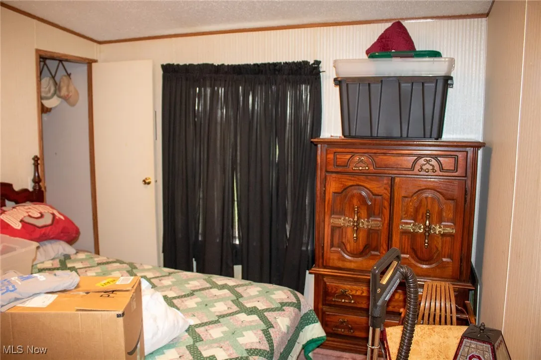 Bedroom with ornamental molding and a textured ceiling