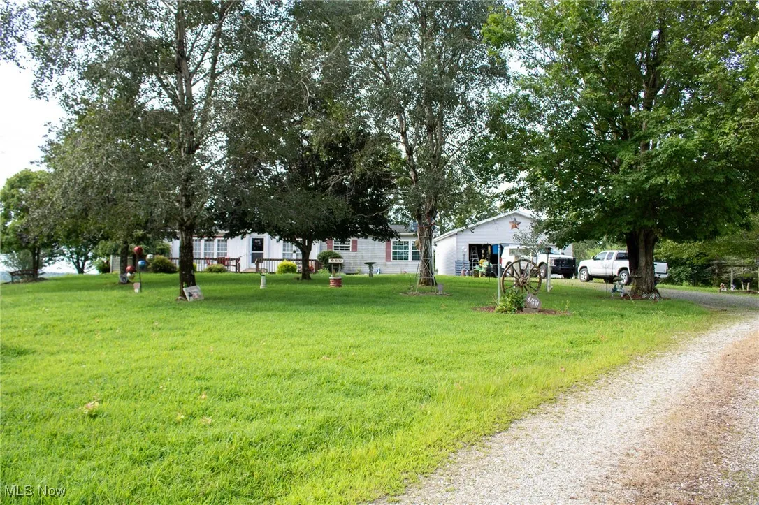 View of grassy yard featuring driveway