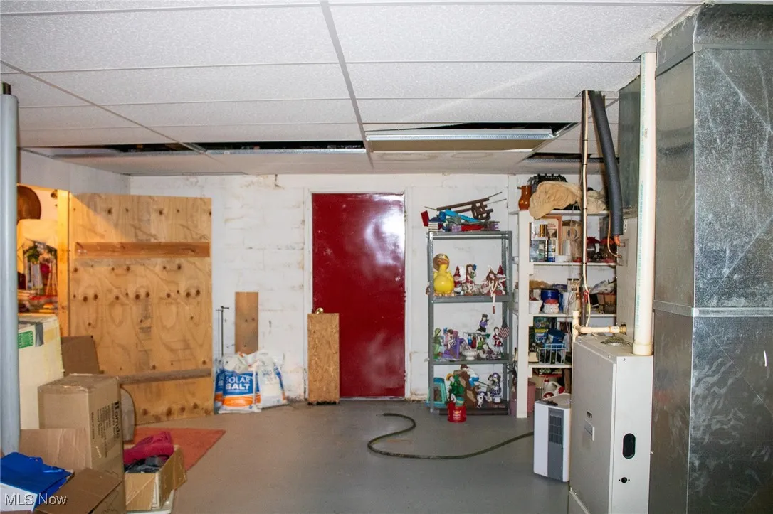 Finished below grade area featuring a drop ceiling and heating unit