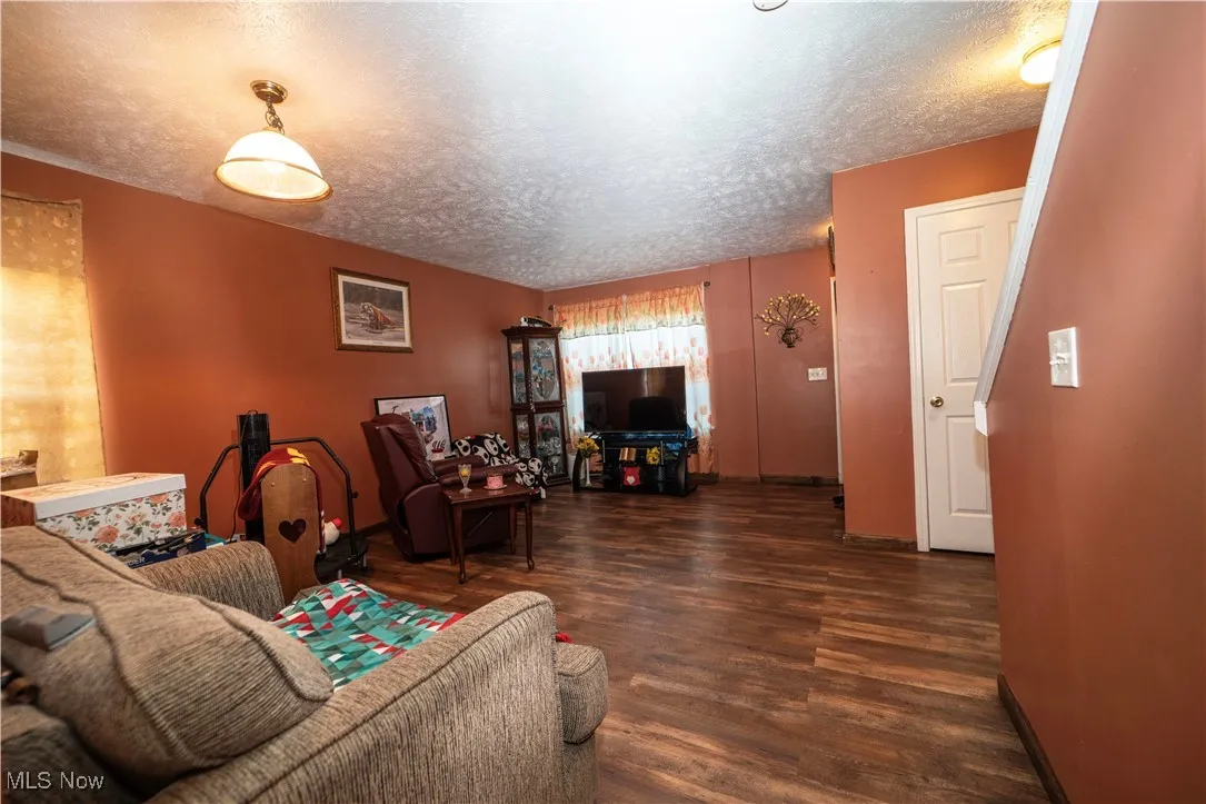 Living room featuring a textured ceiling and wood finished floors