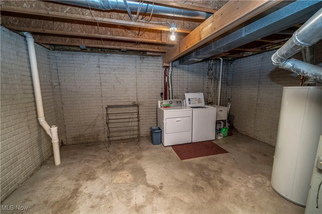 Unfinished basement with washing machine and dryer and water heater