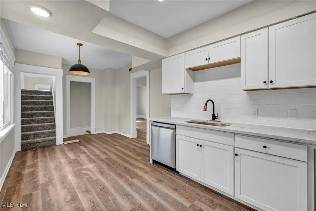 Kitchen featuring decorative backsplash, wood finished flooring, brand new cabinets and quartz countertops