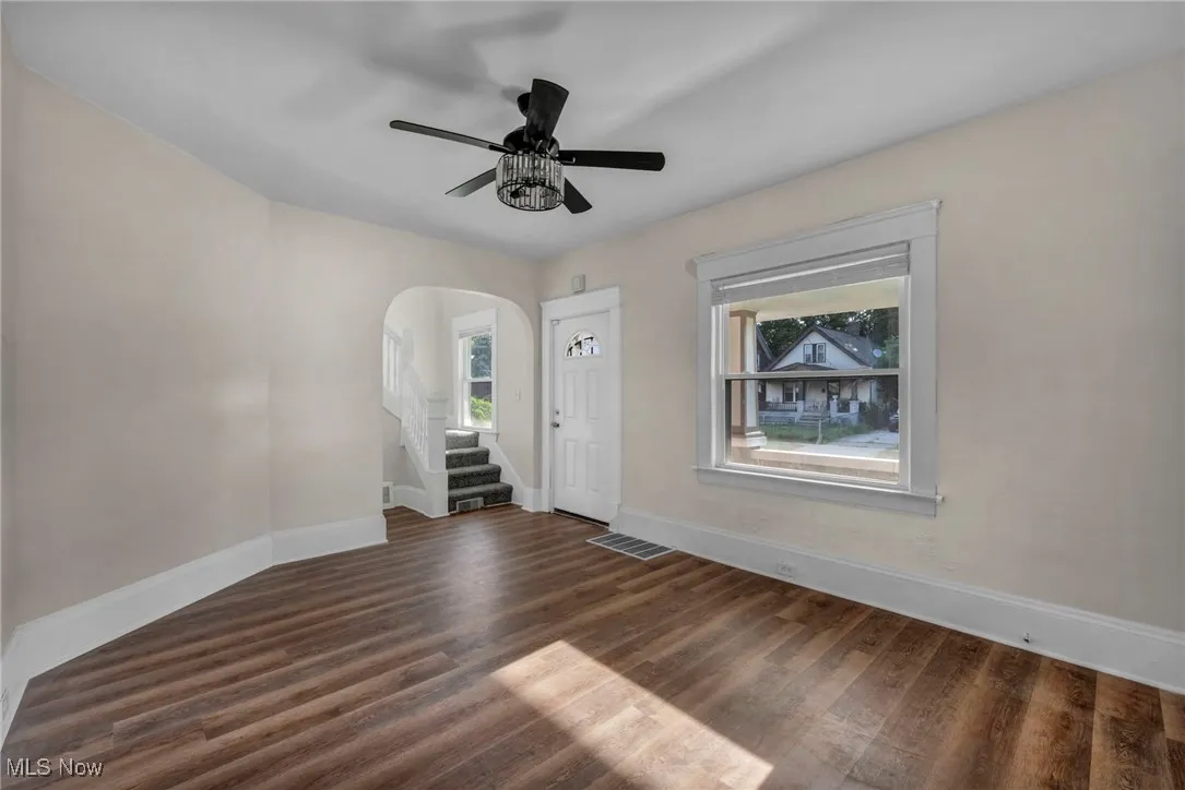 Living room with wood finished floors, and ceiling fan and natural light