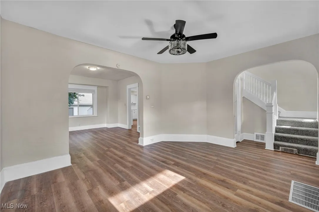Living room with wood finished floors, and ceiling fan and natural light