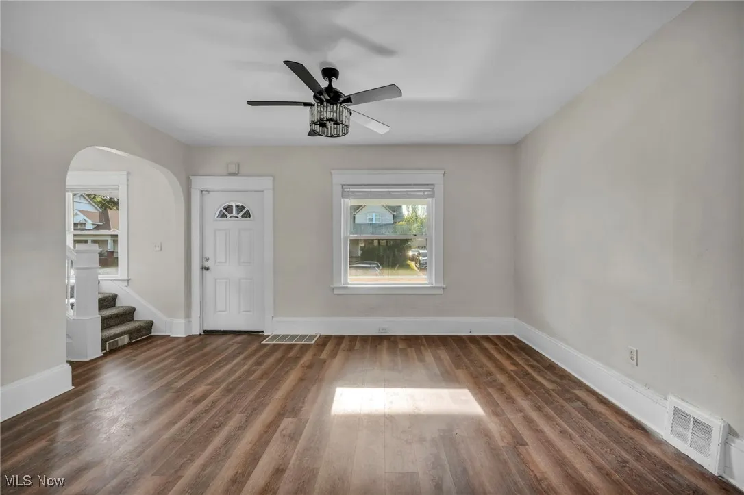 Living room with wood finished floors, and ceiling fan and natural light