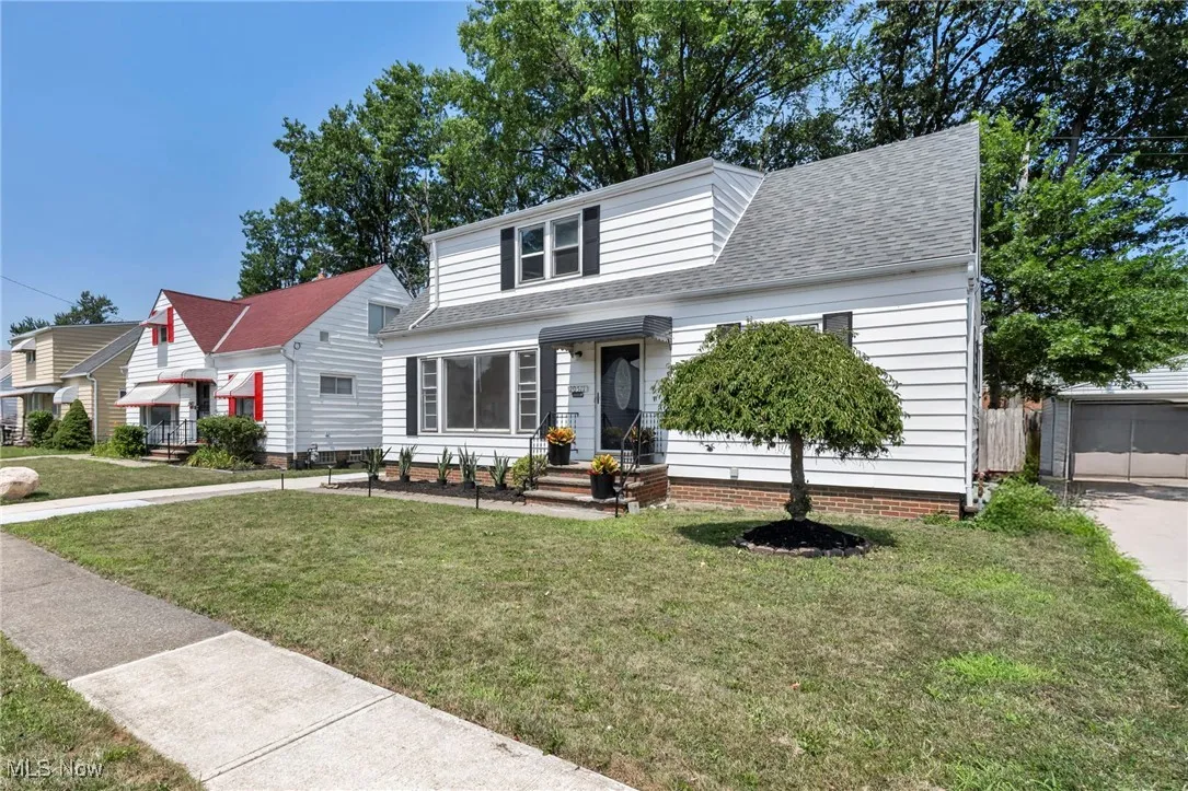 View of front of property featuring a shingled roof and a front lawn