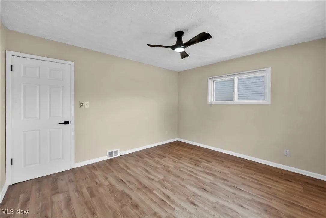 Bed room featuring wood finished floors, a textured ceiling, and a ceiling fan