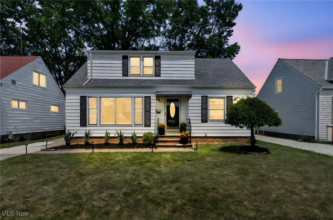 View of front of home featuring a shingled roof and a front yard
