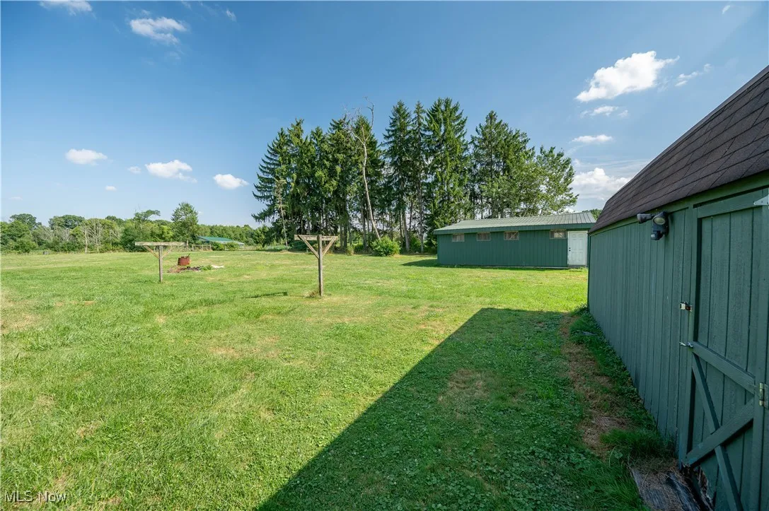 View of green lawn featuring an outbuilding