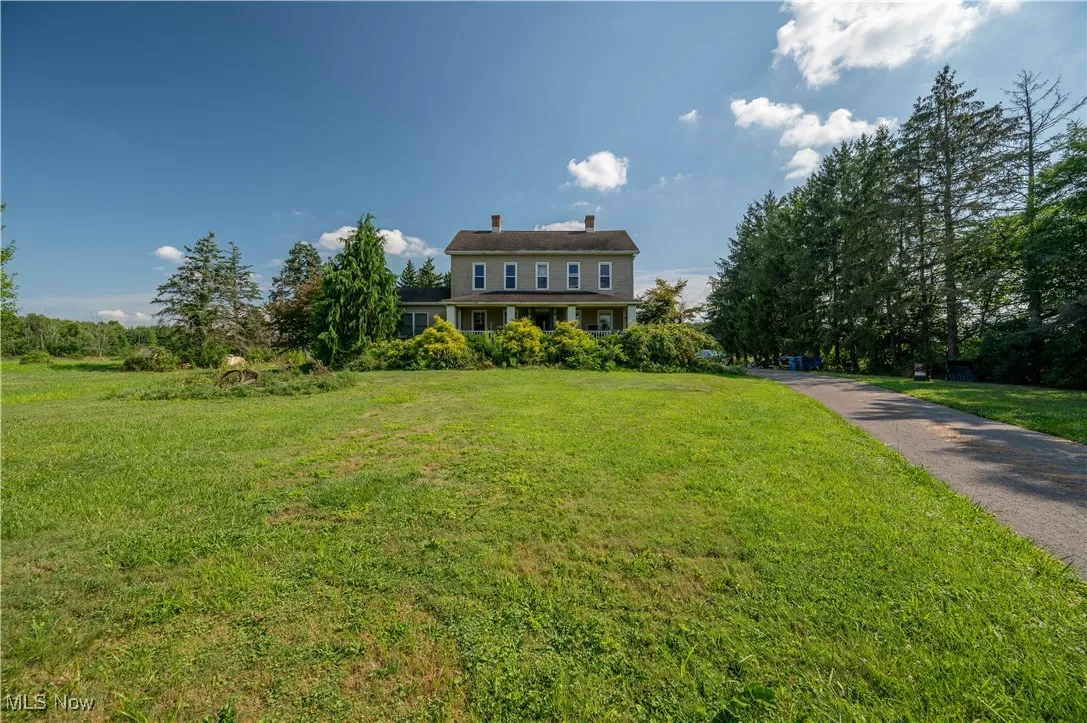 View of front facade with a front lawn and a chimney