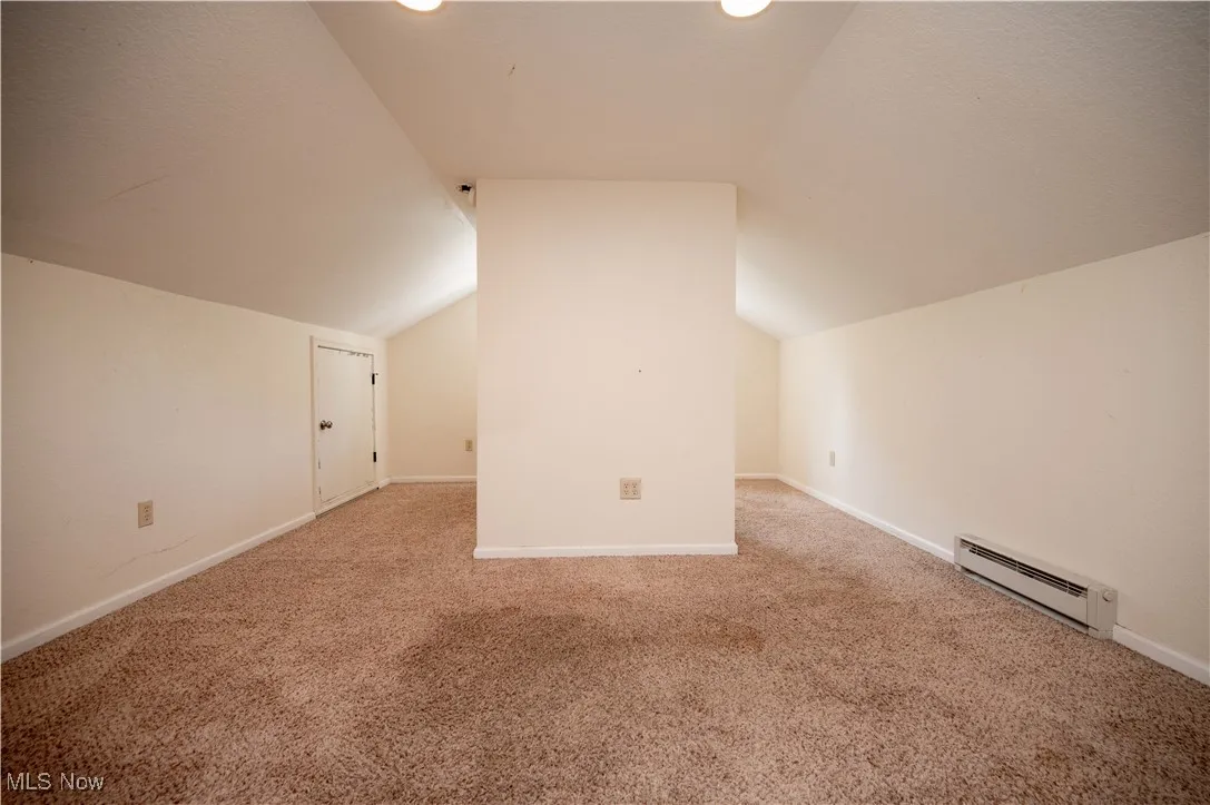 Additional living space with baseboard heating, carpet, vaulted ceiling, and recessed lighting