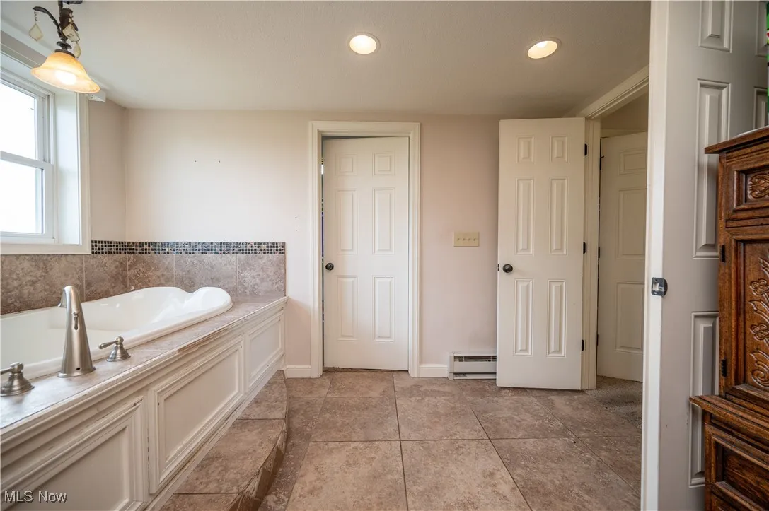 Full bathroom with a bath, recessed lighting, a baseboard heating unit, and tile patterned floors