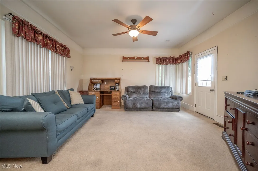 Living room featuring light carpet and ceiling fan
