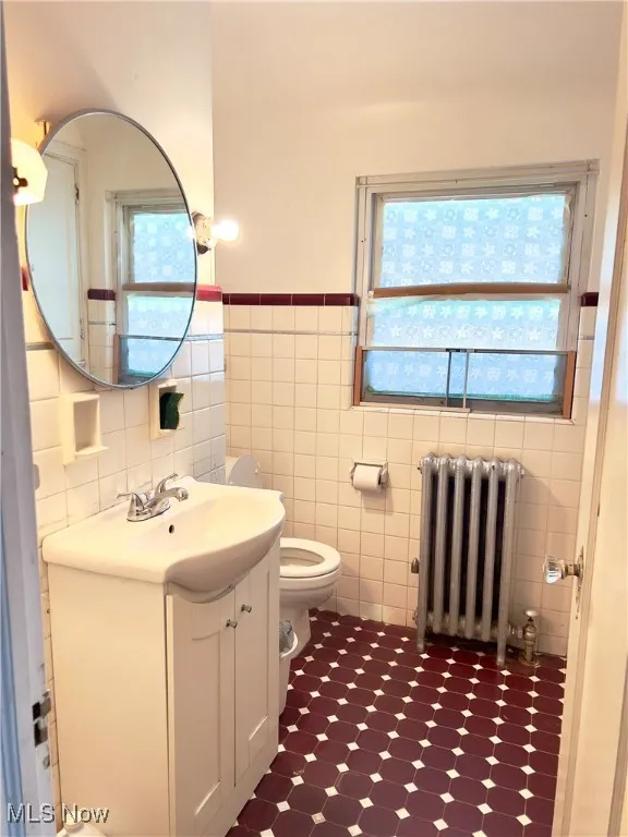 2nd floor Bathroom featuring vanity, radiator heating unit, tile walls, wainscoting, and tile patterned floors