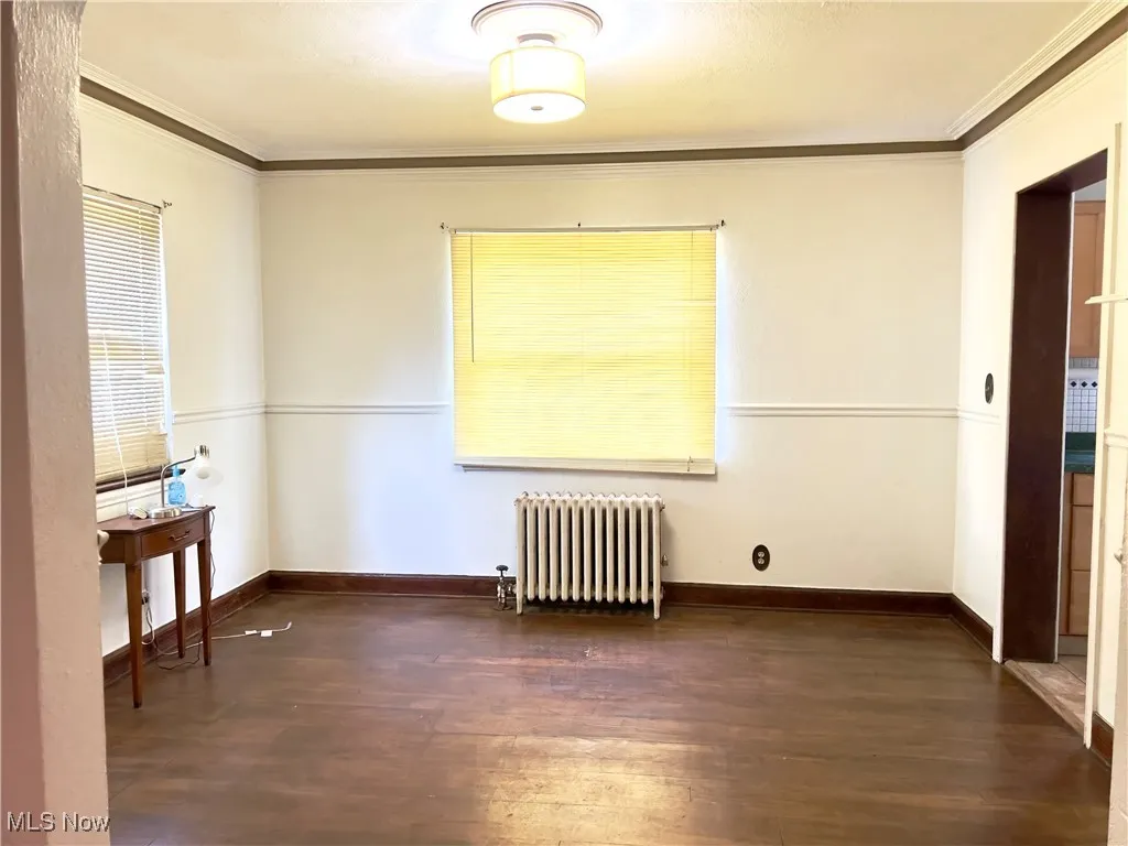 Dinning room featuring ornamental molding, hardwood / wood-style floors, and radiator heating unit